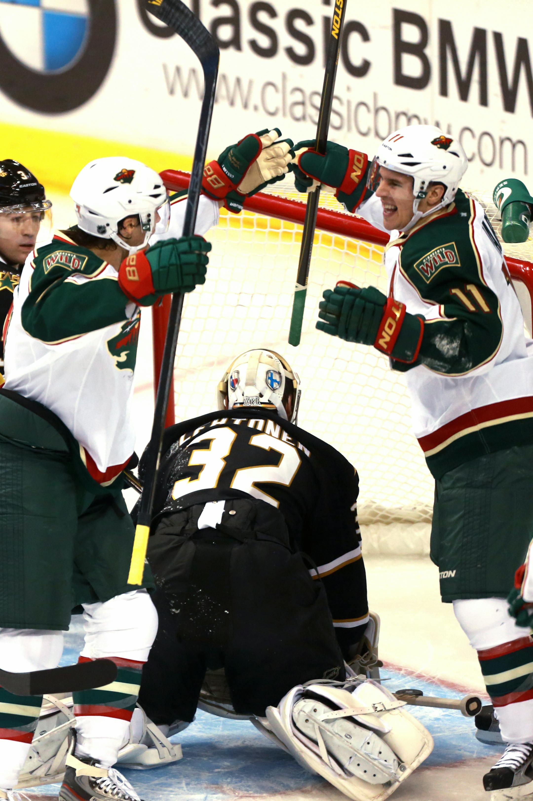 Minnesota Wild center Matt Cullen, left, and teammate Zach Parise (11) celebrate Parise's goal on Dallas Stars goalie Kari Lehtonen (32) during the first period of an NHL hockey game Monday, March 25, 2013 in Dallas. (AP Photo/ Michael Mulvey)