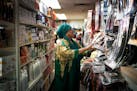 Hajah Konneh, owner of M and B Hair Braiding and Beauty Supply, tidied shelves in her Brooklyn Center store. She is still open, but not many customers