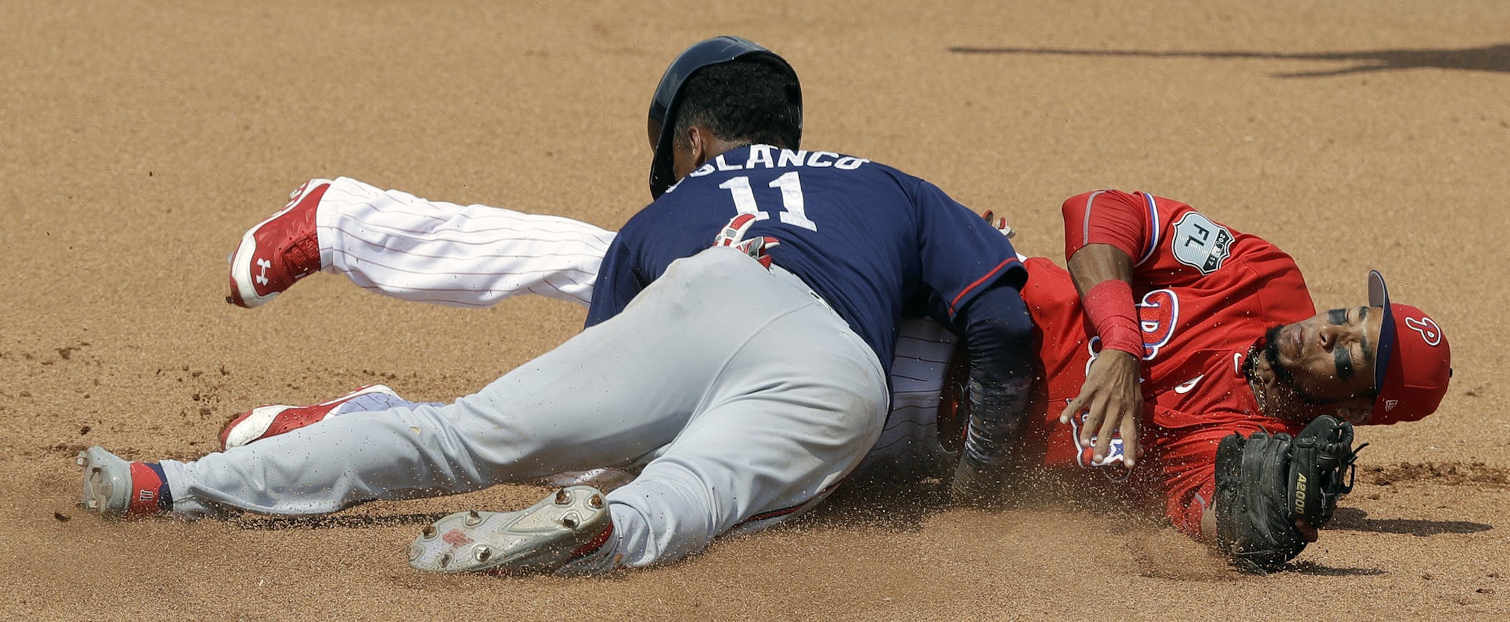 Philadelphia Phillies second baseman Pedro Florimon, right, reaches for a wild throw as Minnesota Twins' Jorge Polanco (11) steals second base during the sixth inning of a spring training baseball game Thursday, March 23, 2017, in Clearwater, Fla. (AP Photo/Chris O'Meara)