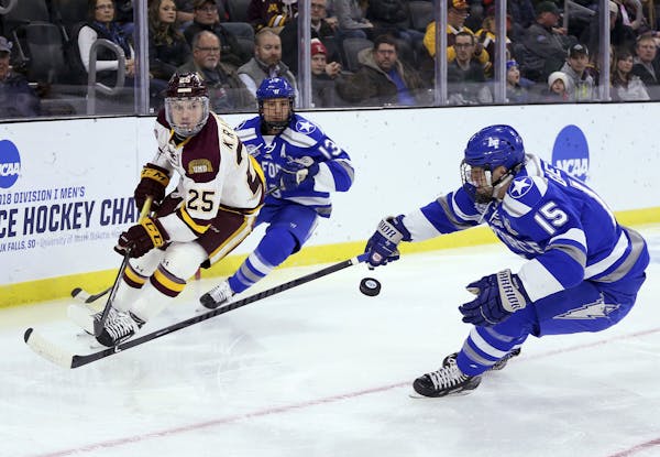 Minnesota-Duluth's Peter Krieger (25) flips the puck past Air Force's Evan Giesler (15) during the first period of an NCAA regional men's college hock