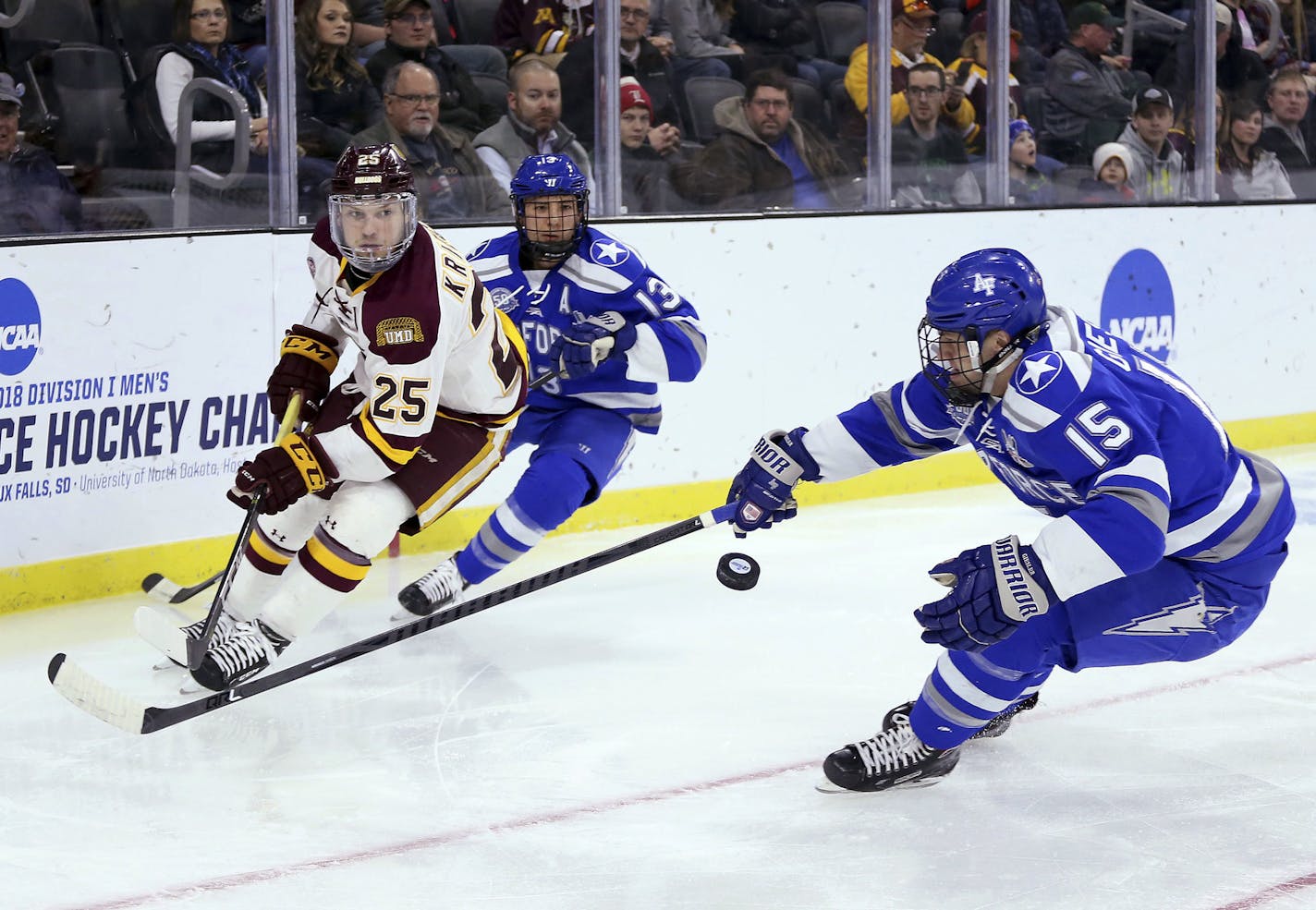 Minnesota-Duluth's Peter Krieger (25) flips the puck past Air Force's Evan Giesler (15) during the first period of an NCAA regional men's college hockey tournament game Saturday, March 24, 2018, in Sioux Falls, S.D. (AP Photo/Dave Eggen)