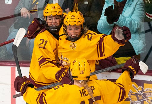 Gophers forward Emily Oden (21) and wing Peyton Hemp (15) celebrate with forward Addie Burton (26) after she scored a goal on Jan. 22