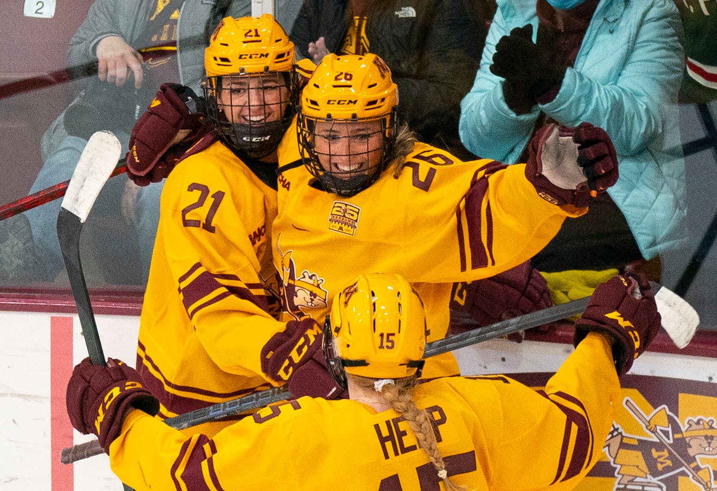 Gophers forward Emily Oden (21) and wing Peyton Hemp (15) celebrate with forward Addie Burton (26) after she scored a goal on Jan. 22