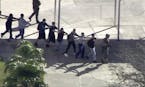 In this frame grab from video provided by WPLG-TV, students from the Marjory Stoneman Douglas High School in Parkland, Fla., evacuate the school follo