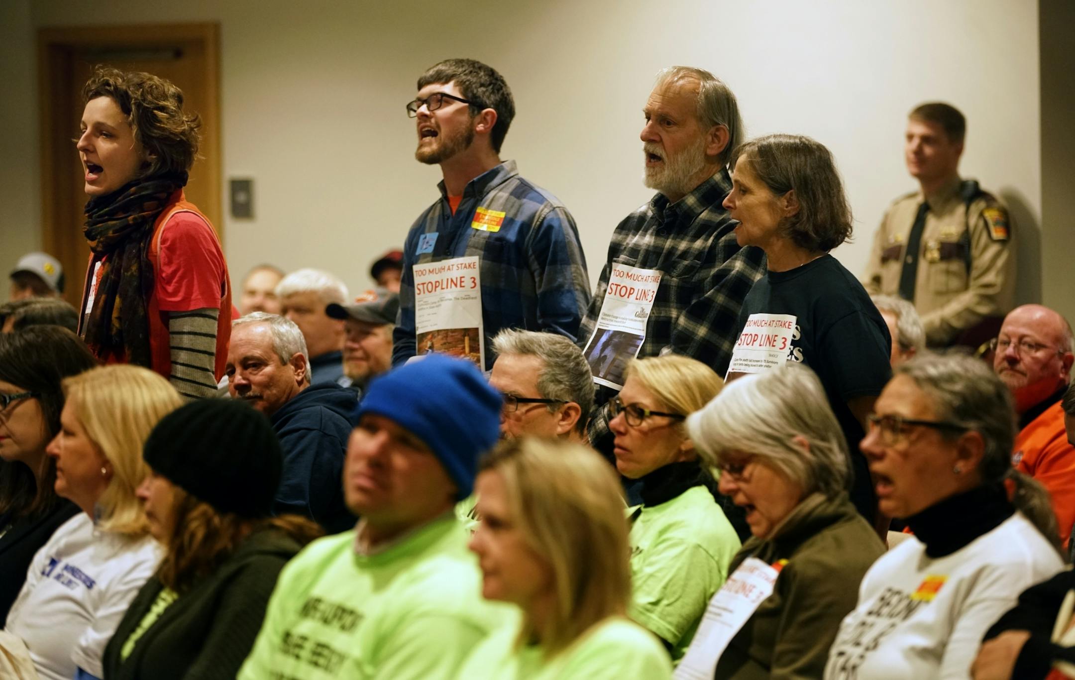 Paige Carlson, far left, and Andy Pearson, of MN350, a climate change environmental group disrupted the ongoing discussions before leaving voluntarily.
