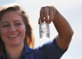 Hannah Young, a community health worker for Hennepin County, demonstrates how water samples are collected at Wayzata Beach Wednesday, July 13, 2016, i