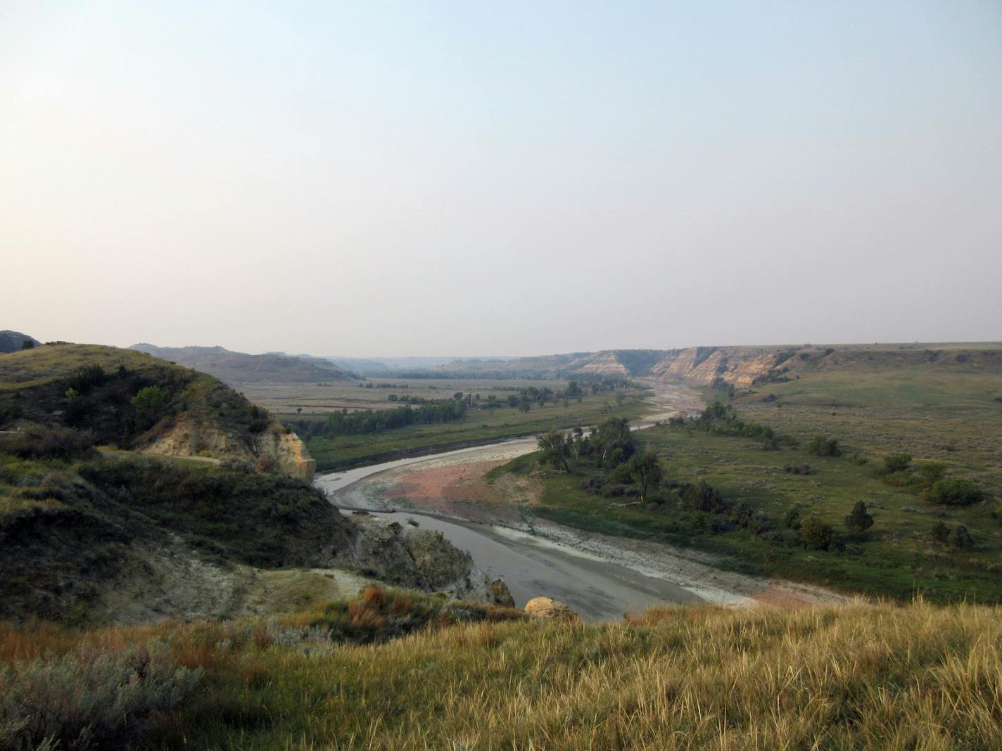 This Sept. 3, 2017 photo shows a curving river at Theodore Roosevelt National Park in Medora, N.D., marking the landscape in colorful patterns as it interacts with soil and stone. Teddy Roosevelt spent time in the area to grieve after his wife and mother died the same day, and his experiences there turned the future president into one of America's greatest conservationists. He described the area as "a land of vast silent spaces _ a place of grim beauty." (AP Photo/Beth J. Harpaz)