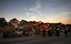 A search and rescue team walks past a debris pile from Hurricane Michael in Mexico Beach, Fla., on Friday.