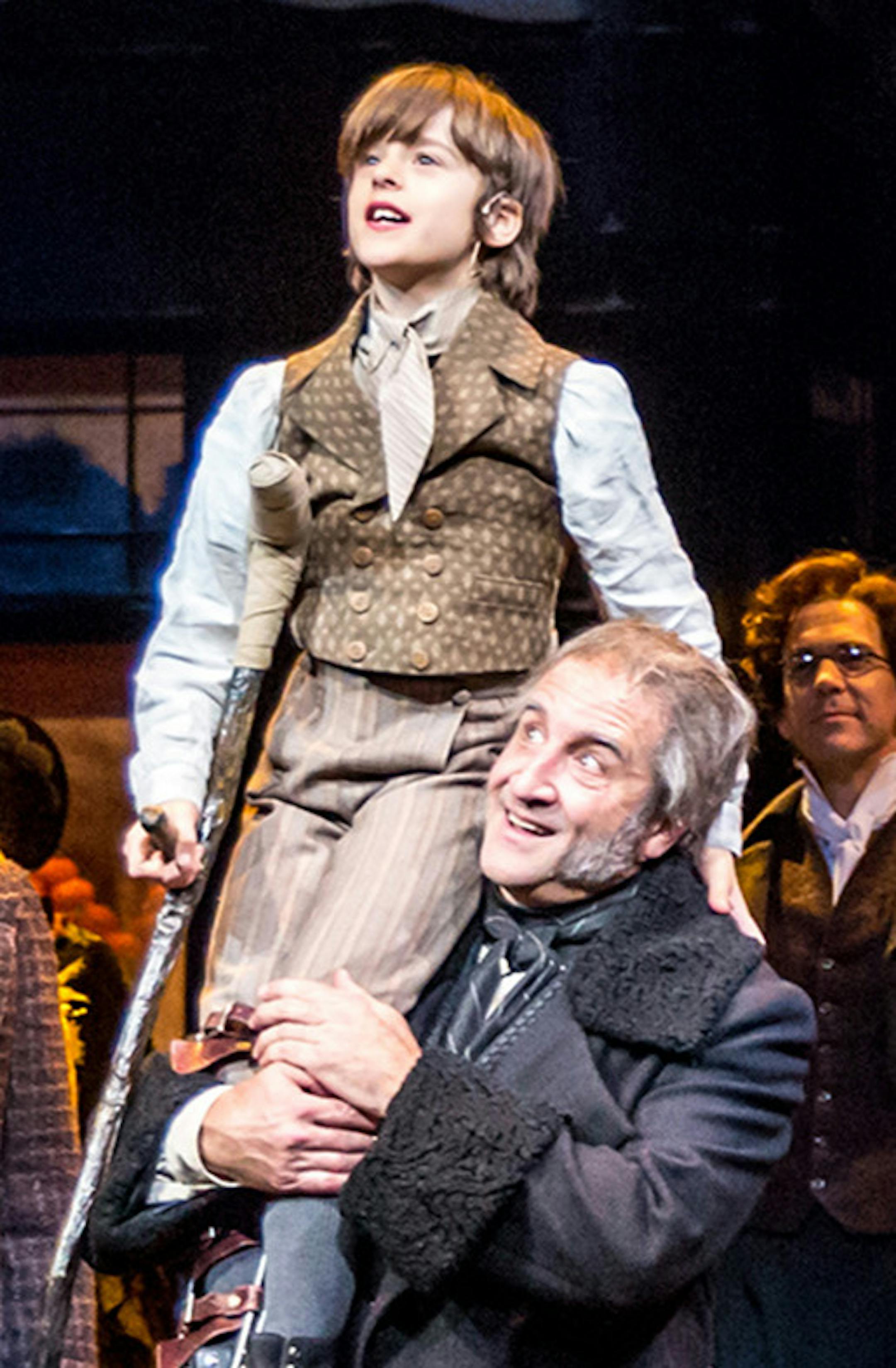 Dan Norman photo credit Kris L. Nelson (Bob Cratchit), Otto Dregni (Tiny Tim) and J.C. Cutler (Ebenezer Scrooge) with members of the cast of the Guthrie Theater's 41st annual production of the Charles Dickens classic, "A Christmas Carol"