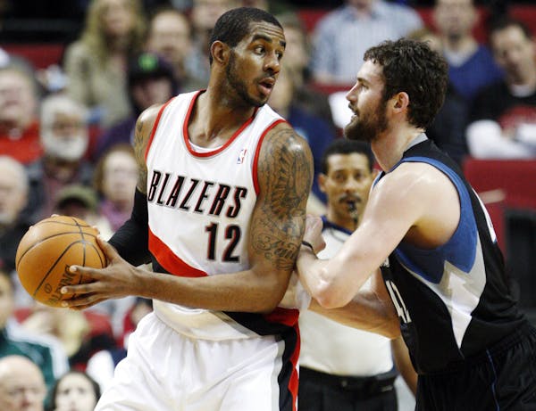 Minnesota Timberwolves' Kevin Love, right, defends against Portland Trail Blazers' LaMarcus Aldridge (12) in the first quarter of an NBA basketball ga