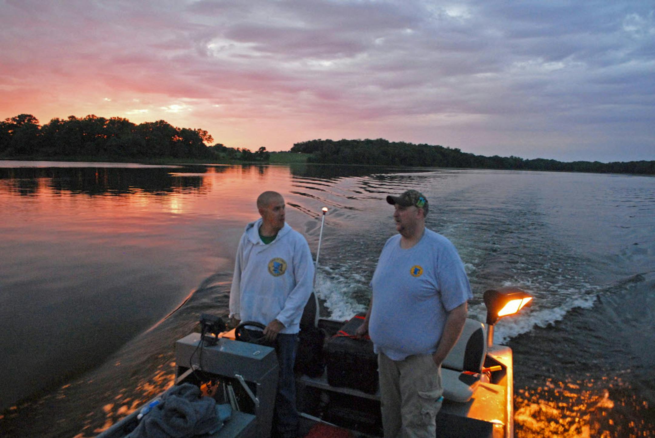 Pat Kirschbaum pilots a specially built bowfishing boat onto Big Marine Lake in anticipation of a good carp fishing night. With him is Brian Pretschel. Both men are past presidents of the Land of Lakes Bowfishing Association.