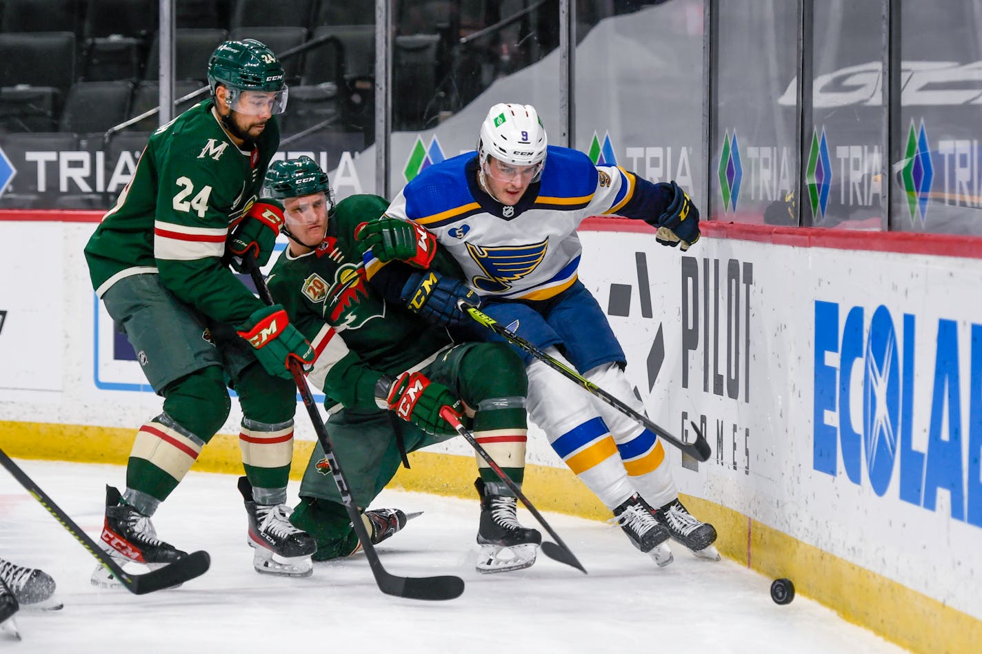 Minnesota Wild defenseman Matt Dumba (24) and center Nico Sturm, center, and St. Louis Blues center Ryan O'Reilly try to control the puck during the second period of an NHL hockey game Wednesday, April 28, 2021, in St. Paul, Minn. The Blues won 4-3. (AP Photo/Craig Lassig)