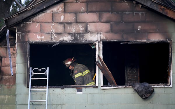 A Minneapolis firefighter looks over the scene of a duplex fire that gutted the upstairs and left two seriously burned Thursday morning.