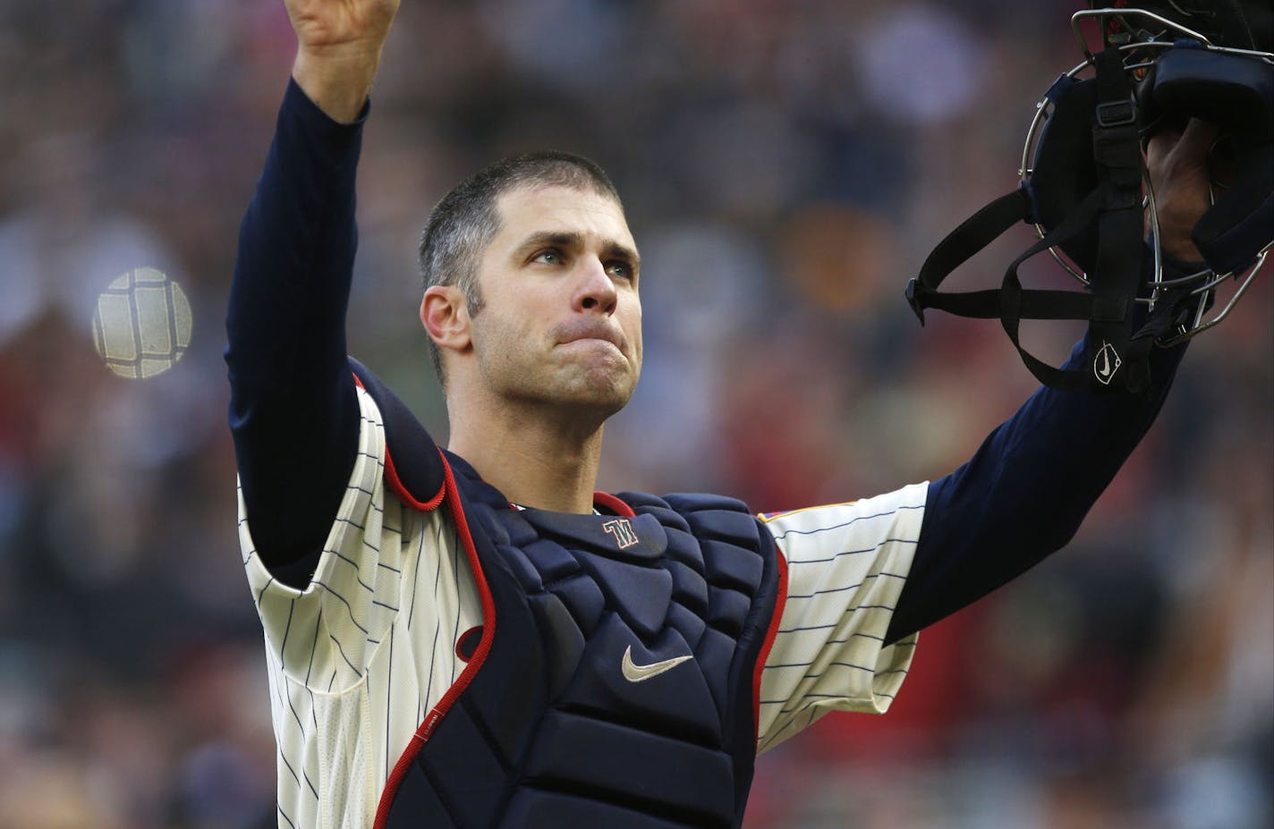 Minnesota Twins' Joe Mauer, the subject of retirement talk, acknowledges a standing ovation as he donned catcher's gear and caught for one pitch against a Chicago White Sox batter in the ninth inning of a baseball game Sunday, Sept. 30, 2018, in Minneapolis. Mauer began his career as a catcher before switching to first base. The Twins won 5-4. (AP Photo/Jim Mone)