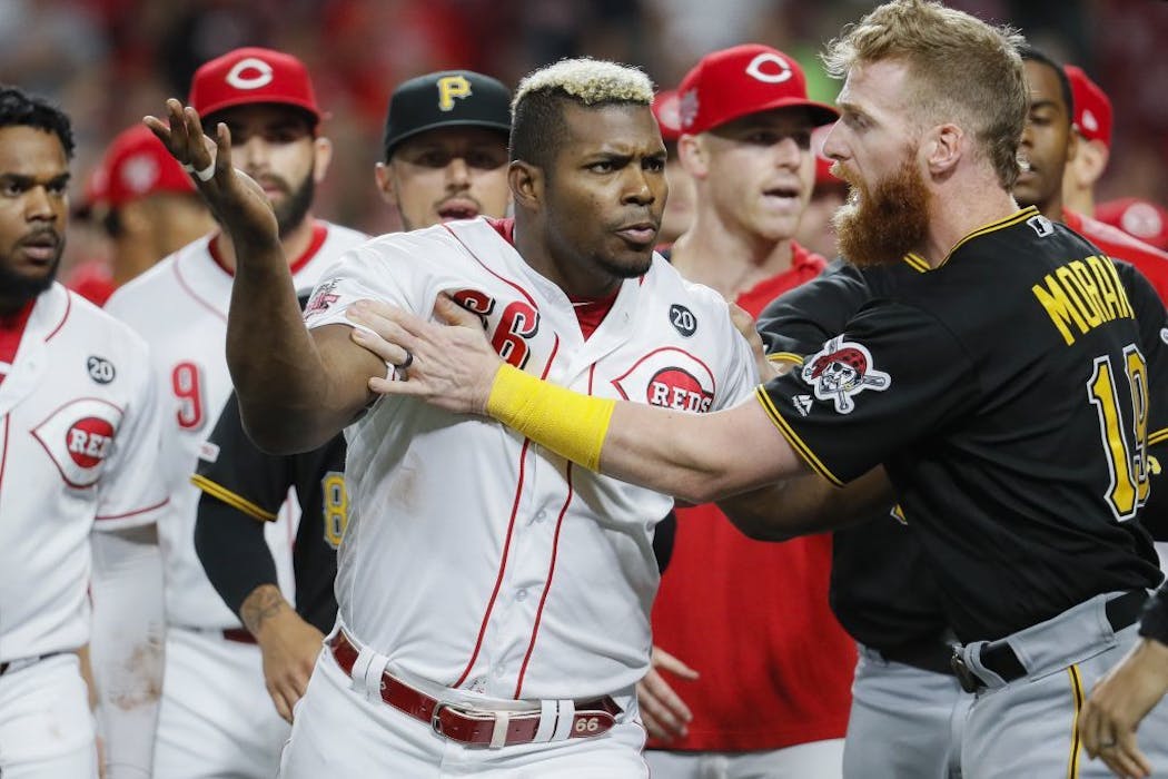 Yasiel Puig (66) is restrained by Pittsburgh Pirates third baseman Colin Moran (19).