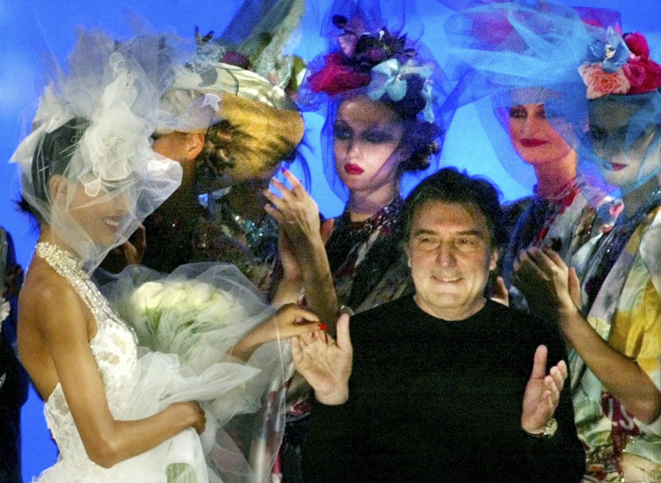 In this Wednesday, Jan. 22, 2003, photo French fashion designer Emanuel Ungaro acknowledges applause at the end of his spring summer Haute Couture 2003 fashion collection presented in Paris. Fashion house Emanuel Ungaro says that French designer Emanuel Ungaro has died at the age of 86. The house posted Sunday, Dec. 22, 2019 on Instagram that Ungaro “will remain in our memories as the Master of sensuality, of color and flamboyance." Ungaro has died on Saturday in Paris, according to Frenc