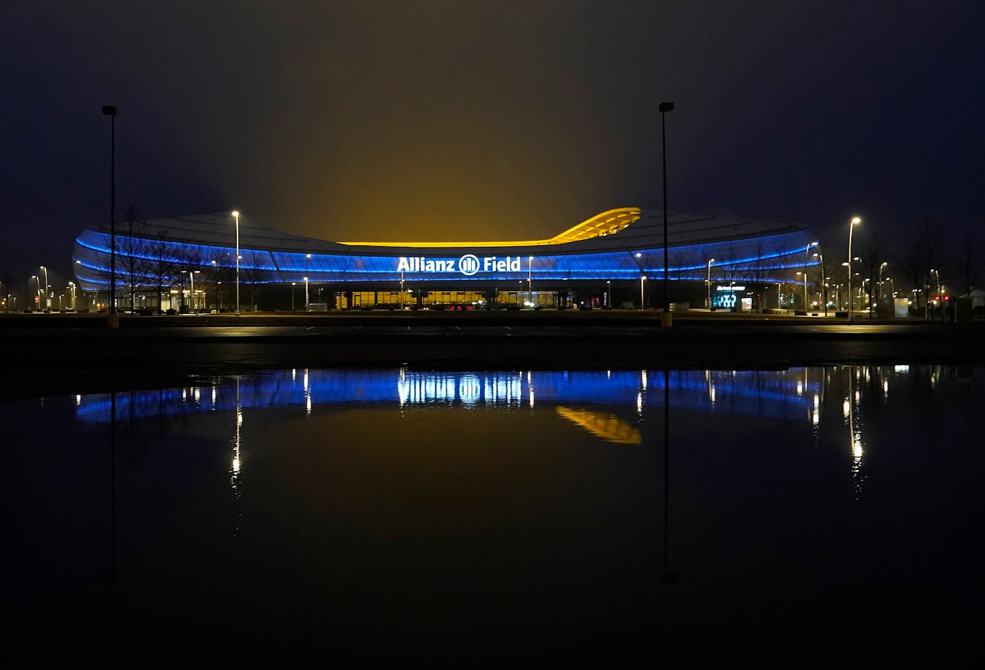 Overnight rain created a pond in a parking lot north of Allianz Field, reflecting the soccer stadium Wednesday, April 13, 2022 in St. Paul, Minn. Parts of Minnesota were walloped by severe storms with lighting, high winds and heavy rain overnight while in northwest Minnesota large amounts of snow fell. ]