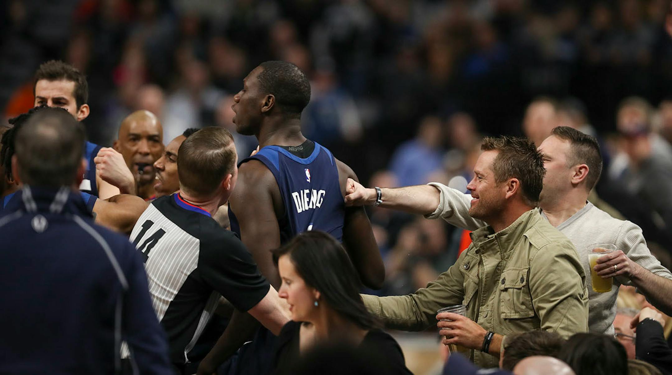 Minnesota Timberwolves center Gorgui Dieng (5) was helped back up - or punched - by fans sitting courtside after he was shoved into the seats by Houston Rockets guard Gerald Green in the fourth quarter.