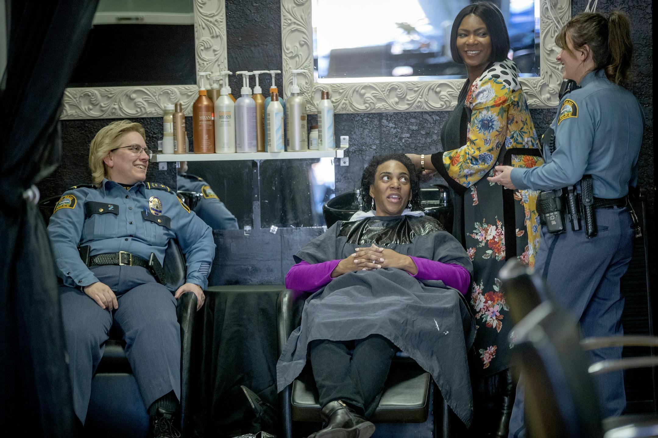 St. Paul Chief Deputy Mary Nash, left, visited with owner of Sense of Style beauty salon Torih Michelle Holmes, right, customer Latesa Pye, center, and Senior Commander Shari Gray, to bring awareness about recruiting more black women to join the police department. ] ELIZABETH FLORES &#x2022; liz.flores@startribune.com