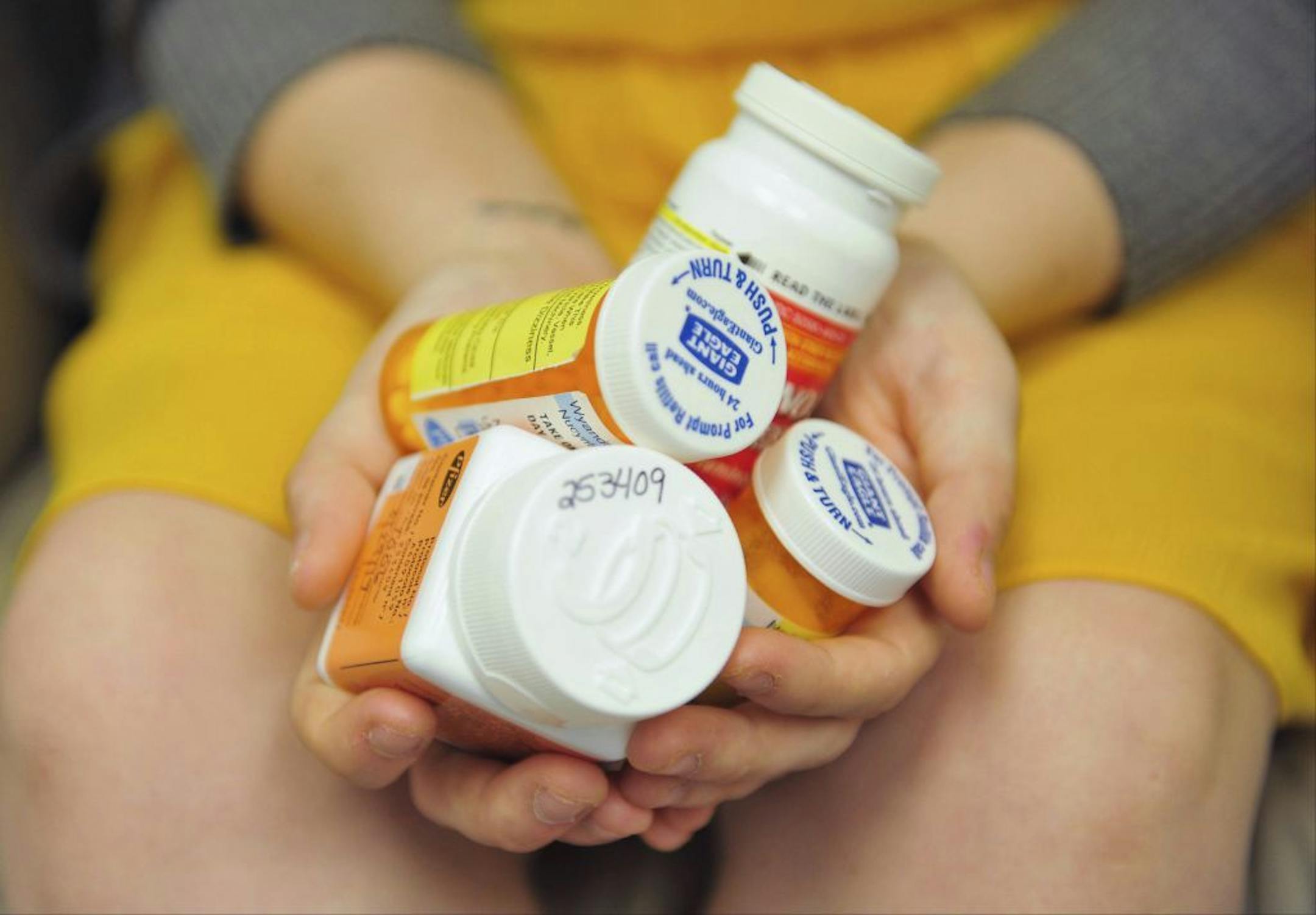 Heidi Wyandt, 27, holds a handful of her medication bottles at the Altoona Center for Clinical Research in Altoona, Pa., on Wednesday, March 29, 2017, where she is helping test an experimental non-opioid pain medication for chronic back pain related to a work related injury she received in 2014.