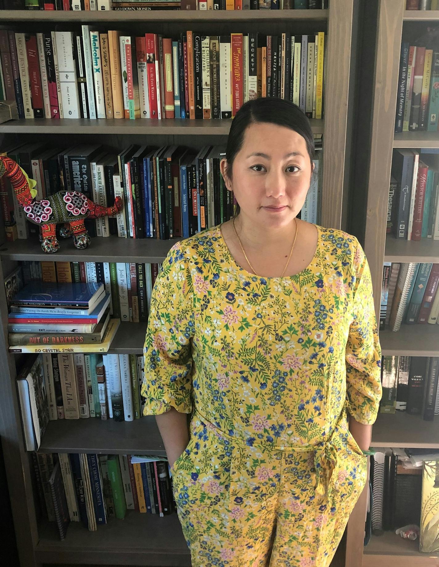 Kao Kalia Yang and her bookshelf.