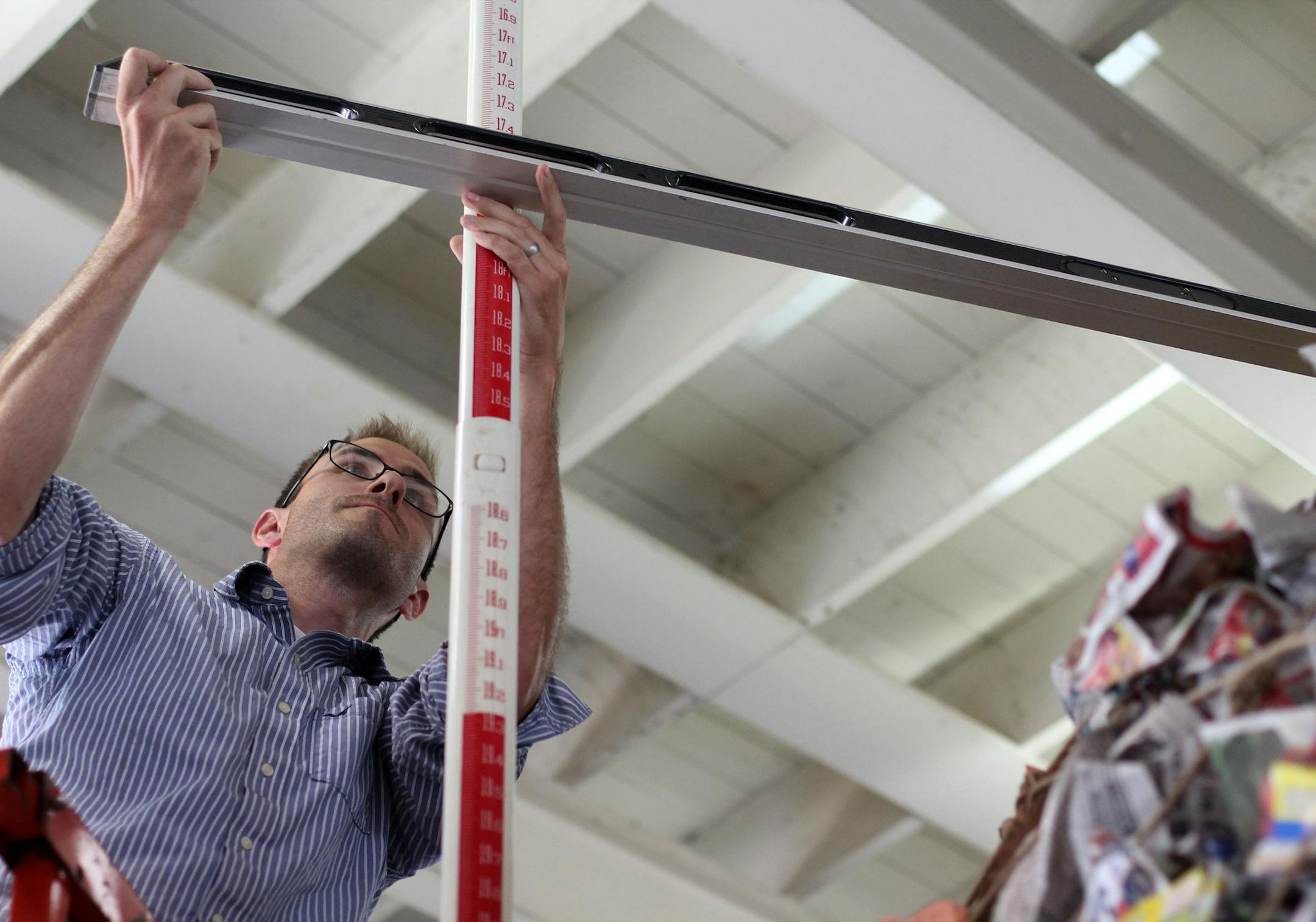 Nate Straka measures the height of a giant paper ball created by the Minnesota Pollution Control Agency on Wednesday afternoon at the State Fair.] The Minnesota Pollution Control Agency created what they hope to be the world's largest ball of paper, weighing 426 pounds, with an average circumference of 32.22 feet. On Wednesday afternoon, a surveyor from Three Rivers Park district took the official measurements. The ball will be on display in the Eco Experience Building at the State Fair. MONICA