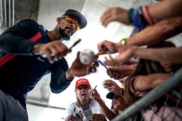 Minnesota Twins' Byron Buxton autographs items for fans on the first full squad practice.