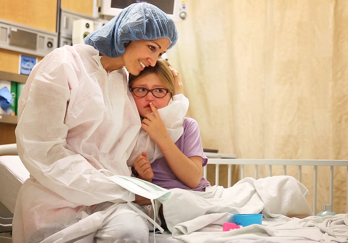 Reagan Lennes, 6, is consoled by her mom, Lisa Lennes, before heading into surgery at Hennepin County Medical Center in downtown Minneapolis on Tuesday.