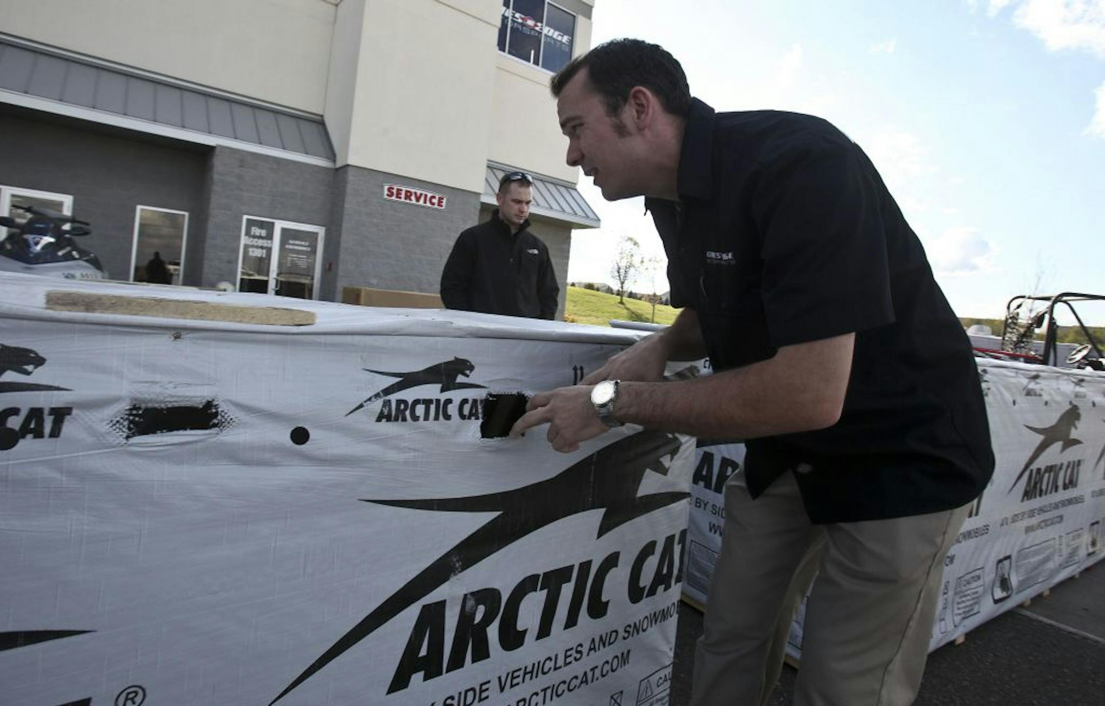 Jason Bittamcourt, a sales rep at Cities Edge Motorsports in Shakopee, looked at crates of new Arctic Cats for customer Brandon Winter.