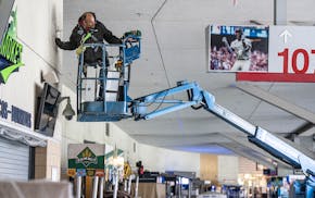 Electrician Bill Barnes makes repairs in a concourse at Target Field. “Year after year, we try to get more energy efficient,” said Dave Horsman, T