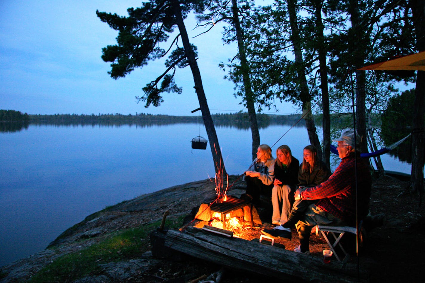 Sarah Ozment, Alyssa Chandler, Natalie Peterson with around the Campfire at Lake Three in the BWCA with their grandfather Ken Johnson.