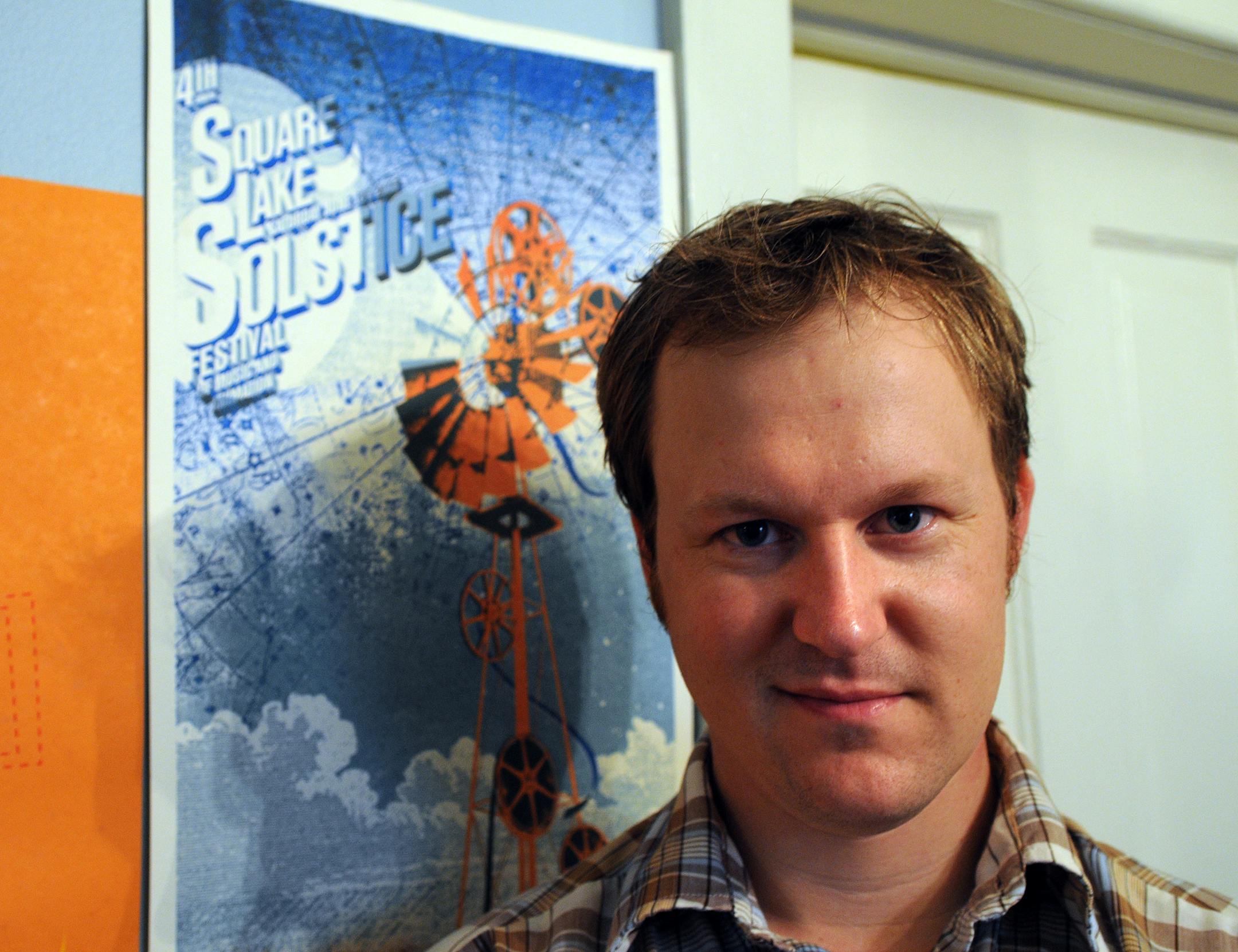 Paul Creager, documentary filmmaker, at home with his editing station and Film festival posters