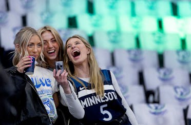 Maddie Knott, 23, Emily Knott, 21, and Lauren Loebrick, 24, all of Lakeville, react after taking selfies in the stands at Target Center tonight.