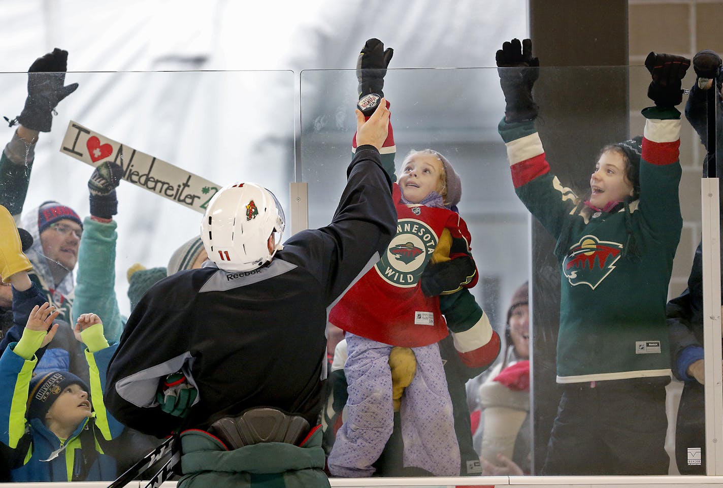 No place like home ice: Forward Zach Parise obliged some young Wild fans with signed pucks during a break at an open Wild practice Monday at the outdoor rink at Braemar Arena in Edina.