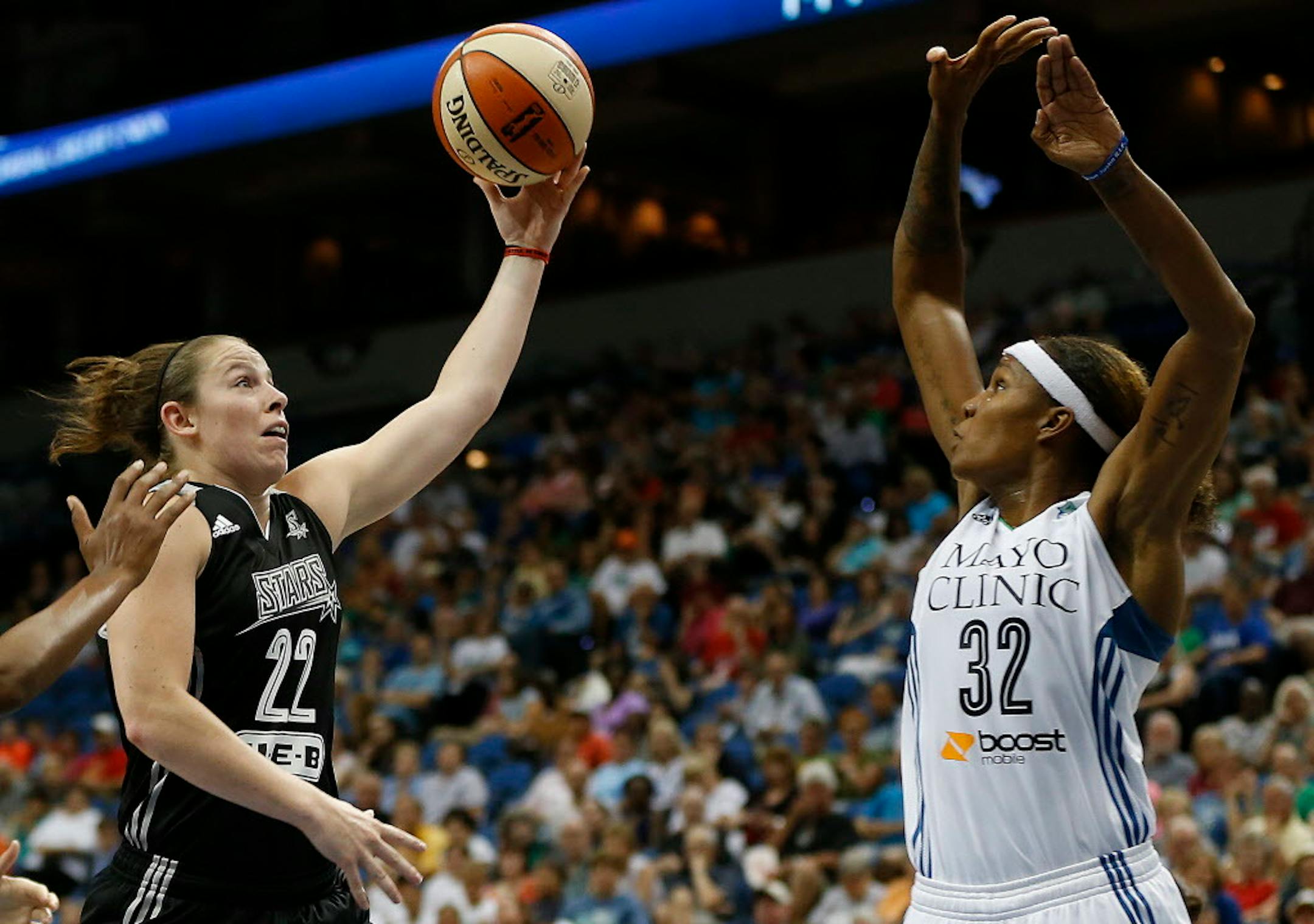 San Antonio Stars guard Samantha Logic (22) shoots the ball against Minnesota Lynx forward Rebekkah Brunson (32) during the first half of a WNBA basketball game, Sunday, July 12, 2015, in Minneapolis. (AP Photo/Stacy Bengs)