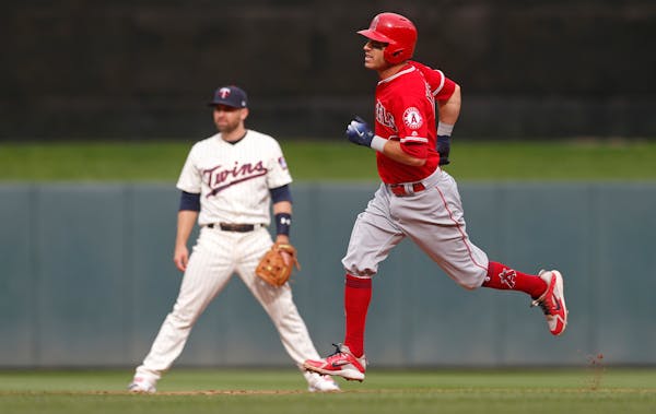Los Angeles Angels' Ian Kinsler, right, passes by Minnesota Twins second baseman Brian Dozier as he rounds the bases on a solo home run off Twins pitc