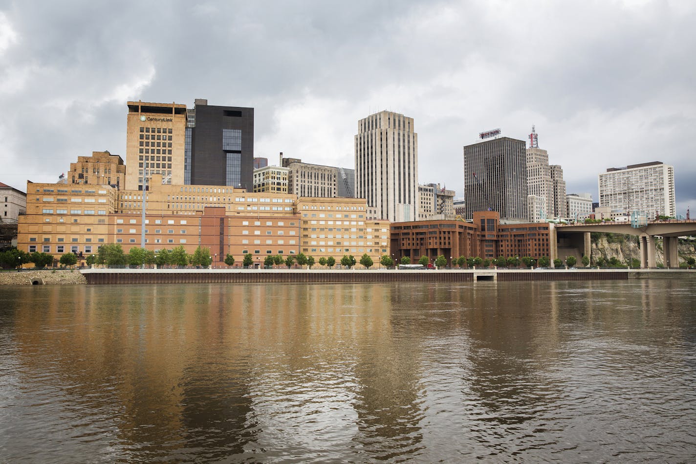 The former West Publishing building, long tan building on left, and former Ramsey County jail building, squat reddish-brown building on right, are seen from across the Mississippi River in downtown St. Paul on Friday, May 29, 2015. ] LEILA NAVIDI leila.navidi@startribune.com / BACKGROUND INFORMATION: This June, Ramsey County will begin razing the former West Publishing building and Ramsey County jail along the St. Paul's downtown river bluff to make way for a sale and new development of the area