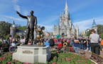 Guests watch a show near a statue of Walt Disney and Mickey Mouse at Walt Disney World near Orlando, Fla.