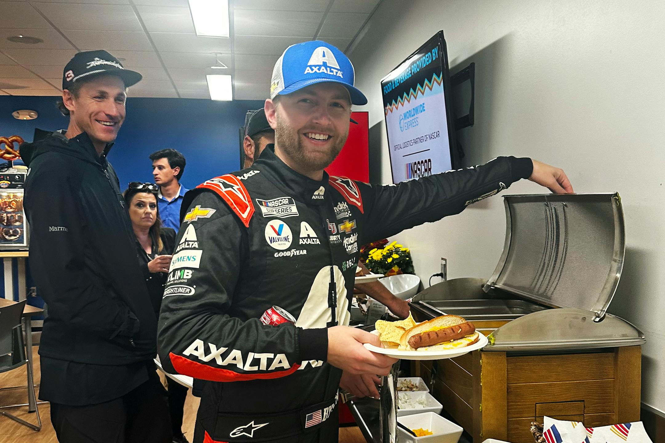 Driver William Bryon makes a hot dog at Phoenix Raceway in Avondale, Ariz. on Thursday