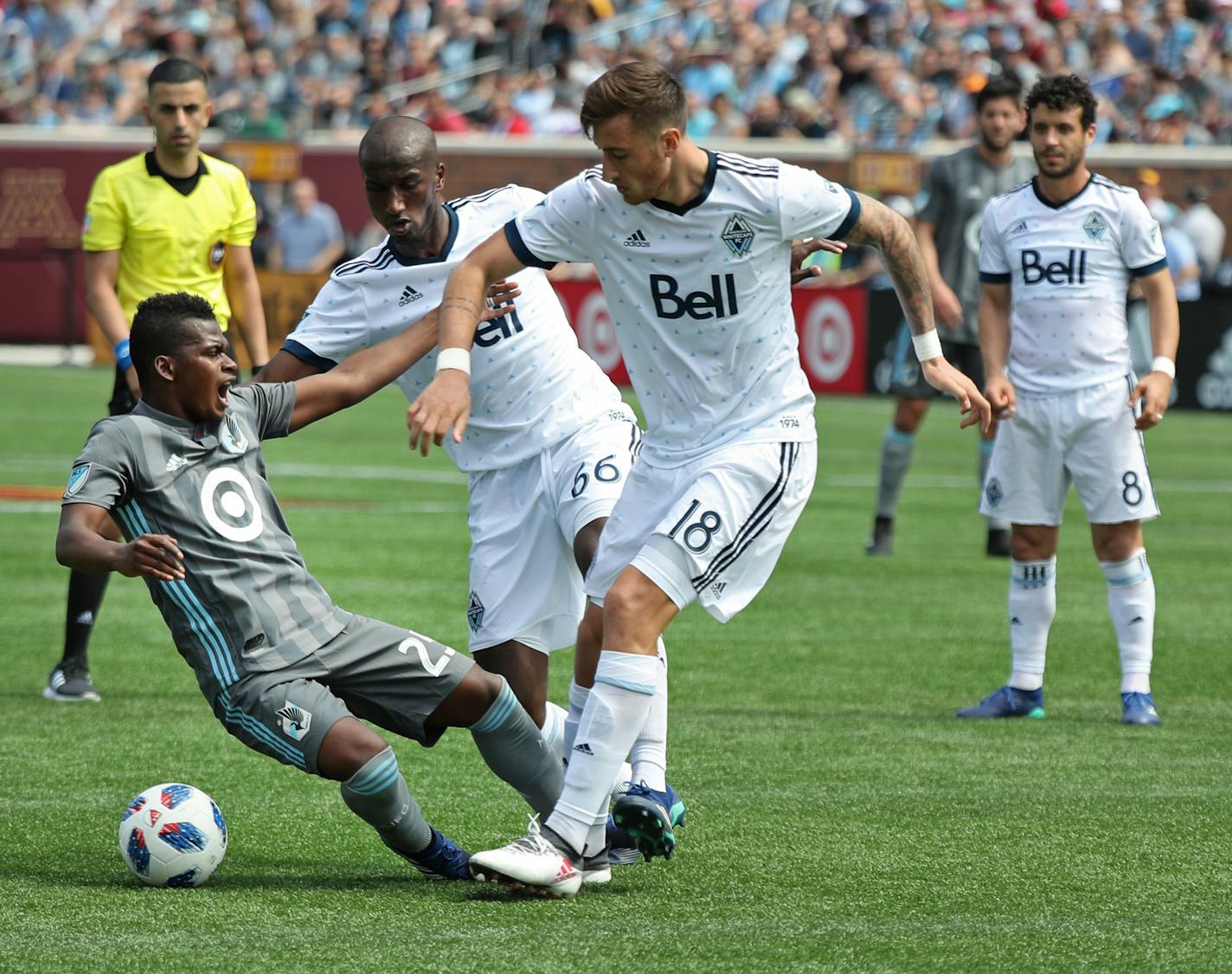 Darwin Quintero is tacked by Vancouver's Aly Ghazal (66) and José Aja (18) in 2018.