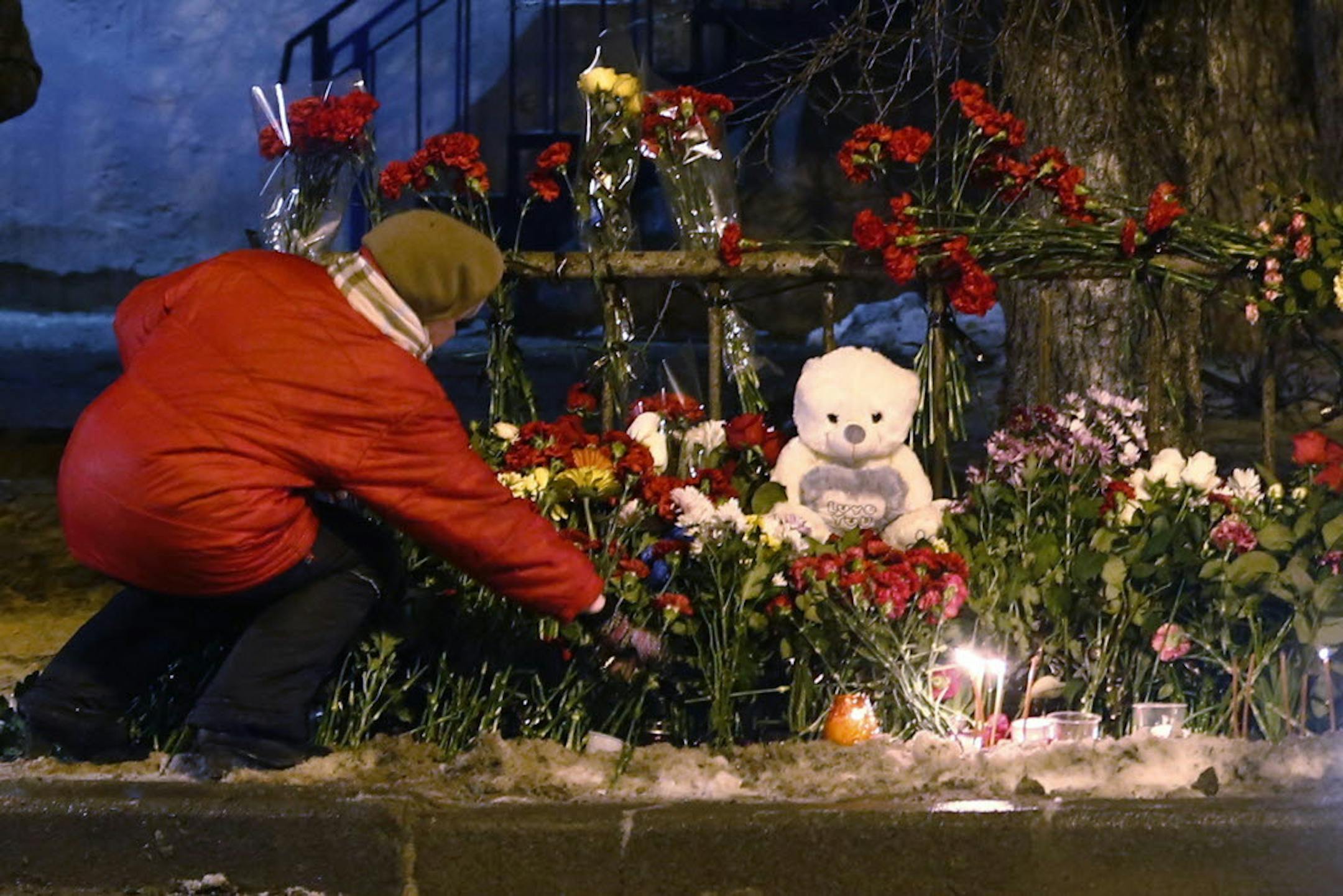 A women puts a flower outside a wreckage of a trolleybus in Volgograd, Russia, Tuesday, Dec. 31, 2013.
