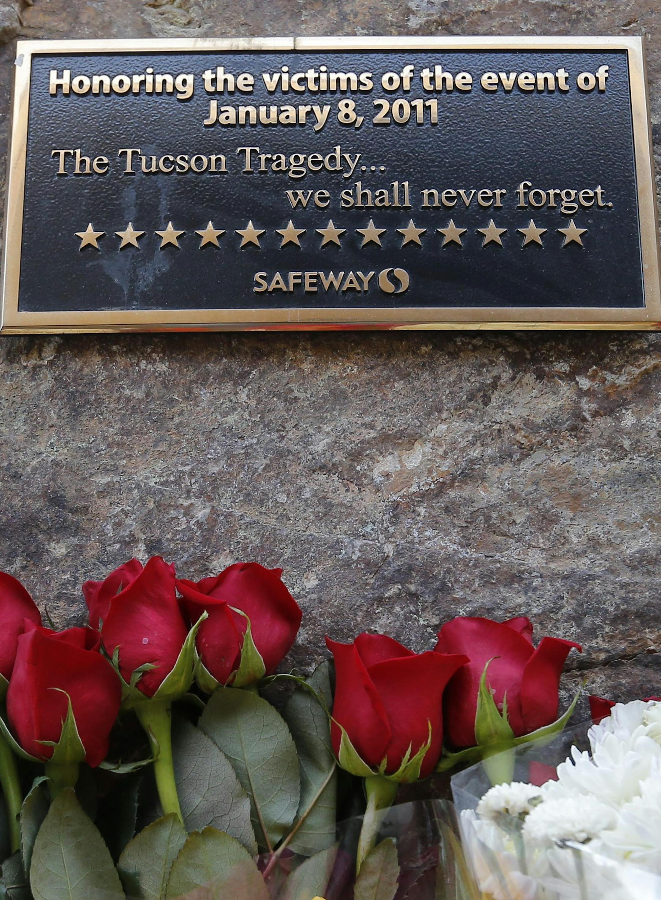 Flowers are lined up on the third anniversary at the site of the Tucson shootings, Wednesday, Jan. 8, 2014, in Tucson, Ariz. Six people were killed and 13 wounded, including U.S. Rep. Gabrielle Giffords, D-Ariz., in the shooting rampage at a community event hosted by Giffords in 2011. Jared Lee Loughner was sentenced in November 2012 to seven consecutive life sentences, plus 140 years, after he pleaded guilty to 19 federal charges in the shooting. (AP Photo/Matt York)