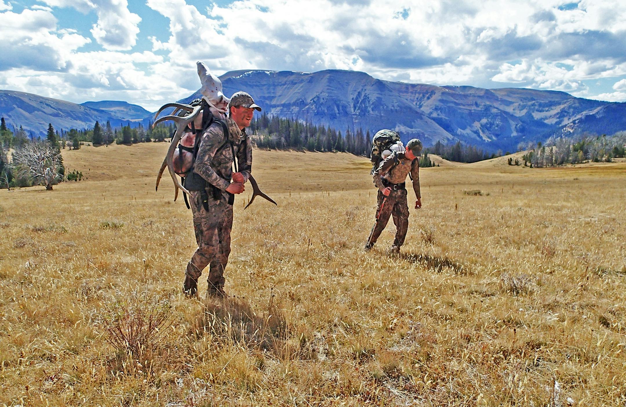 Laden with heavy packs filled with elk meat, Trevor Anderson, left, and Alec Underwood, both of Missoula, Mt., hike toward the tent camp they shared with Dennis Anderson. From their the three began a hike of more than seven miles out of the mountains.