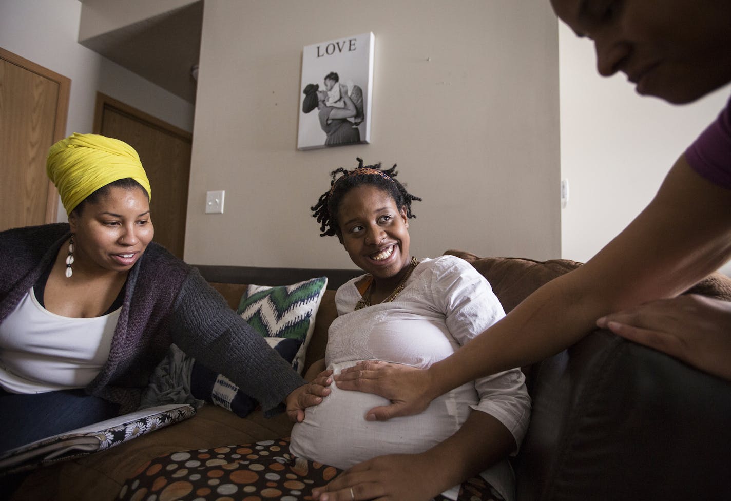 Clara Sharp, left, and Sonja Watley, right, both doulas and co-directors of the company Ahavah Birthworks, visit expectant mother Claire Littleton, center, who is on Medicaid, at her home in north Minneapolis on Wednesday, January 13, 2016. Littleton is due to give birth any day and the doulas were visiting to go over her final birth plan details. ] (Leila Navidi/Star Tribune) leila.navidi@startribune.com BACKGROUND INFORMATION: A new University of Minnesota study makes the case that doula suppo