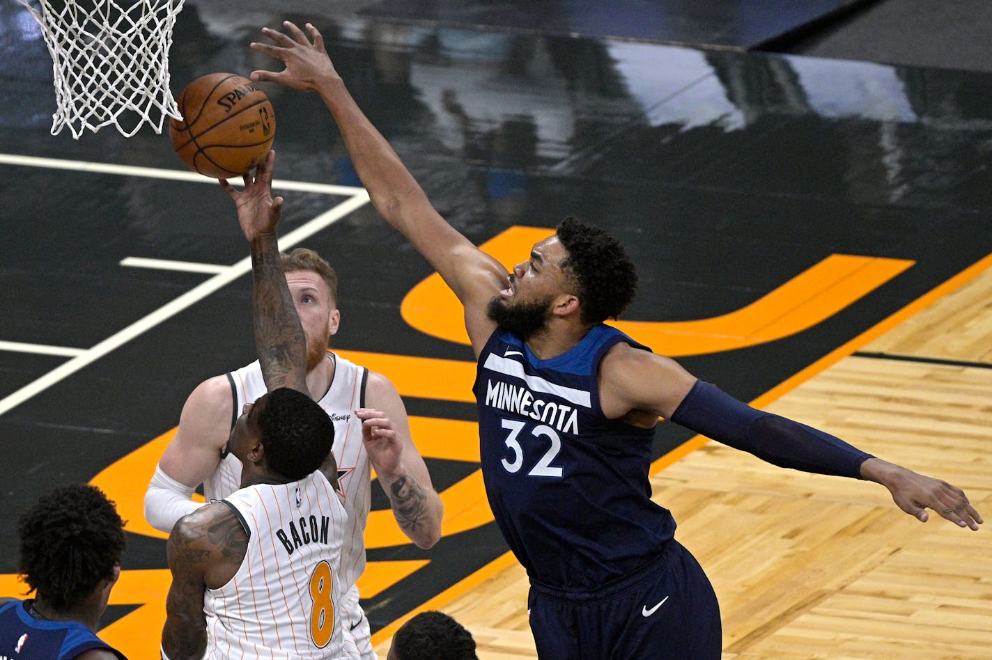 Minnesota Timberwolves center Karl-Anthony Towns (32) blocks a shot by Orlando Magic guard Dwayne Bacon (8) during the first half of an NBA basketball game, Sunday, May 9, 2021, in Orlando, Fla. (AP Photo/Phelan M. Ebenhack)