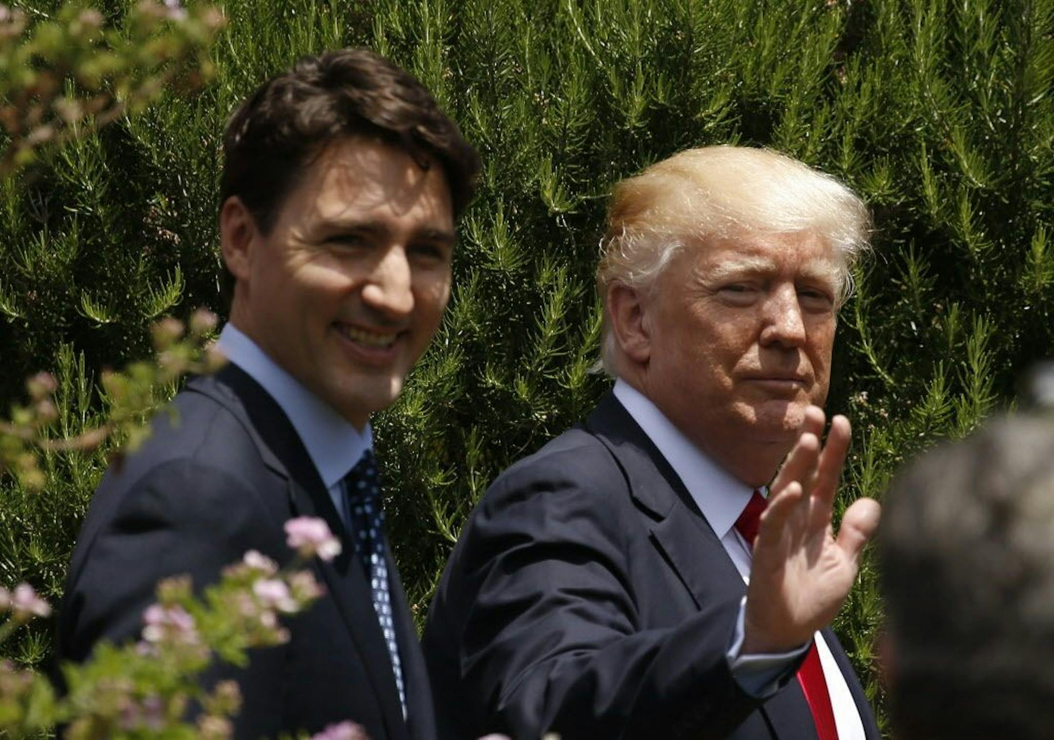 U.S. President Donald Trump and Canadian Prime Minister Justin Trudeau, left, are seen following a family photo of G7 leaders and Outreach partners at the Hotel San Domenico during a G7 summit in Taormina, Italy, Saturday, May 27, 2017.