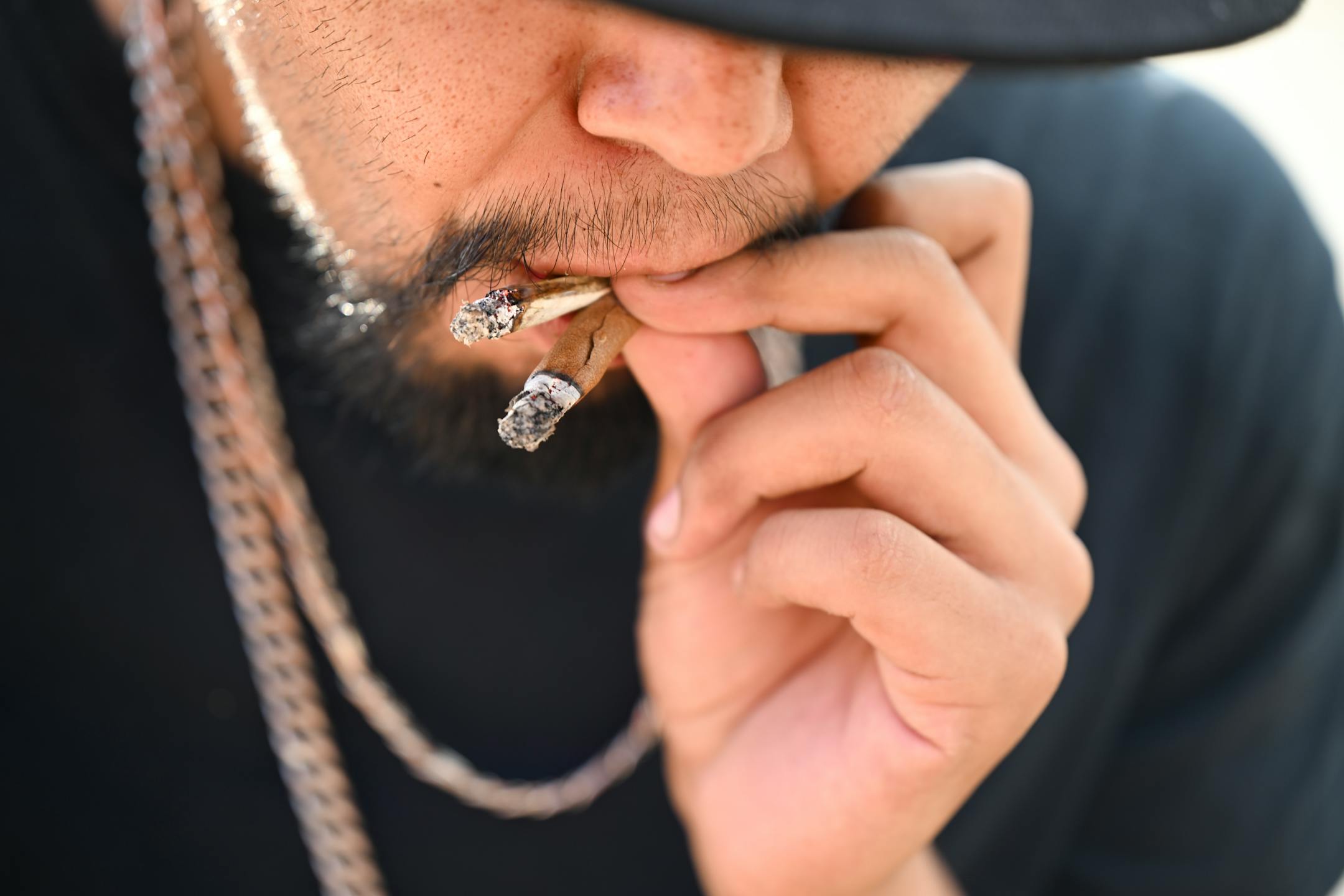 Eugene Sayers, of Red Lake, smokes a blunt and a joint while waiting for the dispensary's opening Tuesday, Aug. 1, 2023 at NativeCare in Red Lake, Minn.