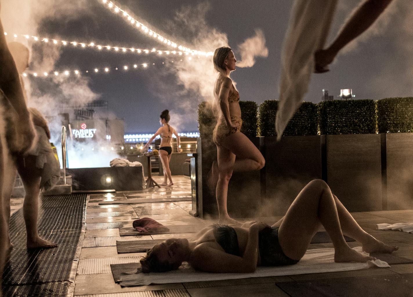 Steam emanates from the bodies of Tricia Sletten, standing center, and others also fresh from the sauna during a cool down in the Aufguss guided steam session hosted by Sauna Society Outfitters and the Hewing Hotel on the hotel's roof in Minneapolis January 12, 2019. It was Sletten's first experience with Aufguss, a German tradition of sauna that incorporates the distribution of steam infused with essential oils. (Courtney Perry/Special to Star Tribune)