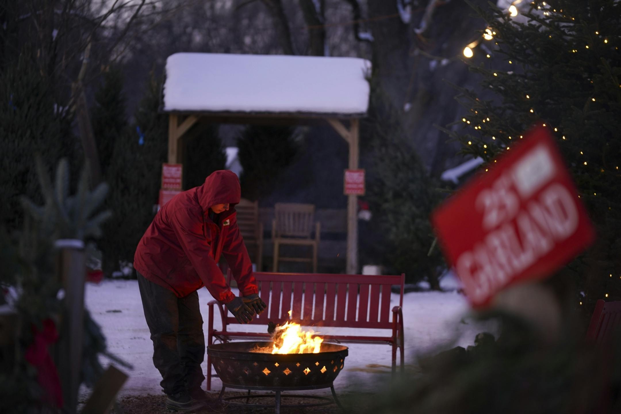 Logan Schilling, 17, the third generation of the Krueger family to work on their Christmas tree farm, warmed his hands by the fire late Tuesday afternoon.