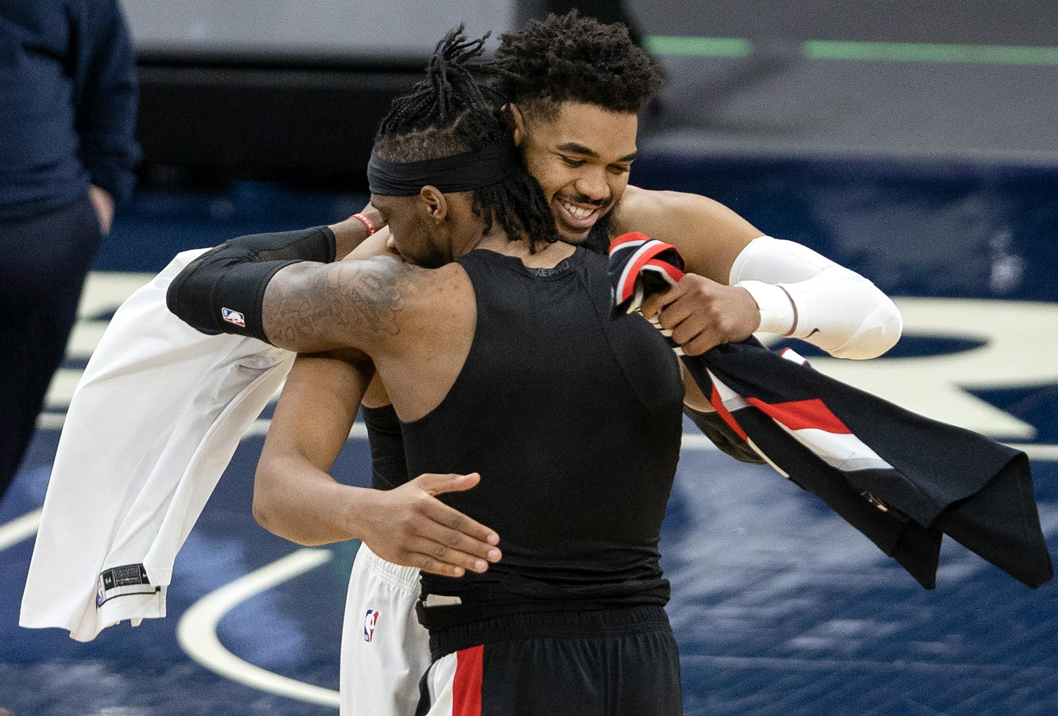 Karl-Anthony Towns (32) of the Minnesota Timberwolves was fouled by Robert Covington (23) of the Portland Trailblazers hugged and traded jerseys at the end of the game.